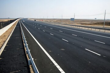 Fototapeta premium Wide-angle shot of black asphalt road with multiple lanes and white dividing lines, urban transportation, highway design