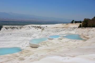 Stunning natural terraces of travertine with turquoise pools in a scenic landscape, Pamukkale, Turkey
