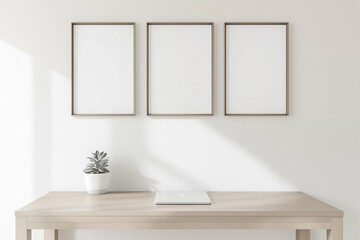 Desk with minimalist decor featuring frames and laptop. Home office setup with desk frames and plant. Modern workspace with minimalist design