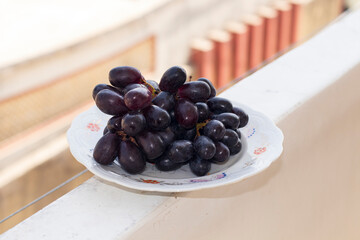 Bunch of fresh Black grapes in the white Dish