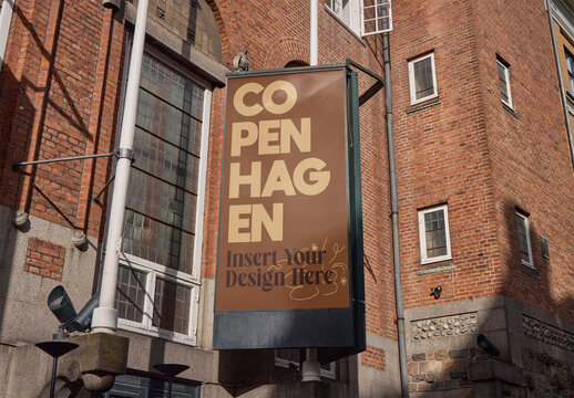 Vertical display positioned against a historic brick building in Copenhagen