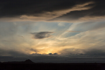 dramatic sky at sunset, thick cloud layer, translucent sun, light, sunset, cirrus clouds, golden, light, blue, cloudscape, meteorology, horizon
