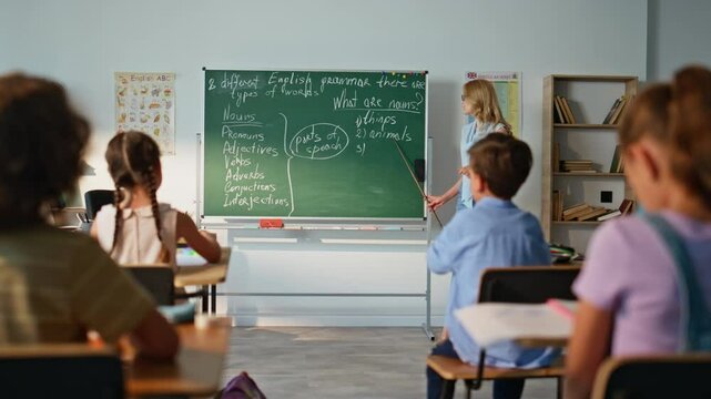 Smiling woman teaching lesson grammar in elementary school. Professional teacher