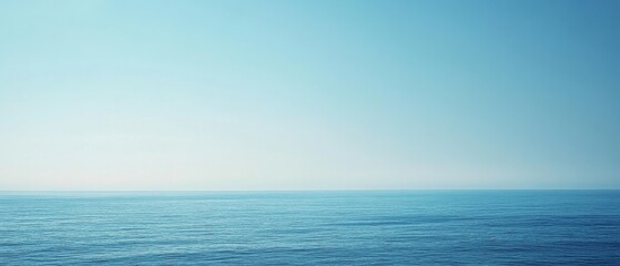 Fototapeta premium Boundless ocean under a soft blue sky creates a tranquil seascape, inviting reflection and calmness in its vast simplicity.
