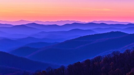 Obraz premium Layered Blue Mountain Ridges at Sunset with Colorful Sky