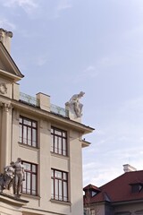 zabytkowy budynek z rzeźbą mężczyzny siedzącym na dachu