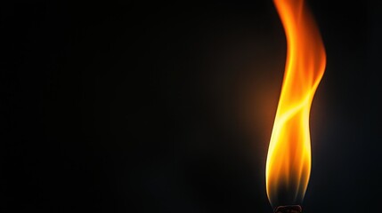 A vibrant orange flame flickers against a dark background, creating a warm and captivating light.