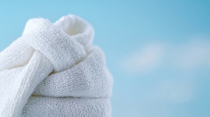 Soft white towel, knotted, blue sky background.  Cleanliness, freshness, spa concept