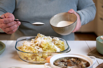 the man puts flour in the potato stuffing