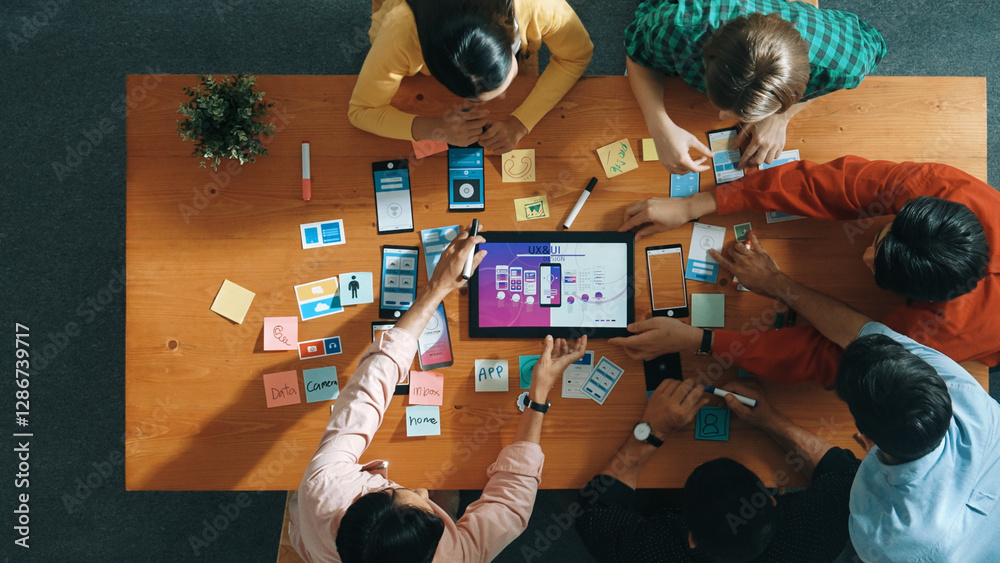 Poster top view of software developer team looking ux ui design for mobile phone interface from tablet whil