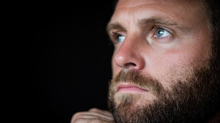 Fototapeta premium Pensive man, thoughtful gaze, dark background, contemplation