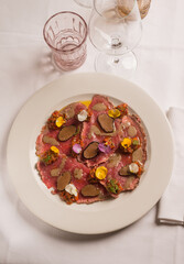 meat carpaccio with sliced truffle and flowers