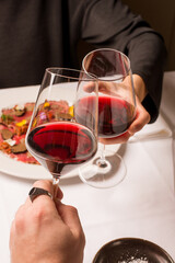 couple toasts with red wine at restaurant