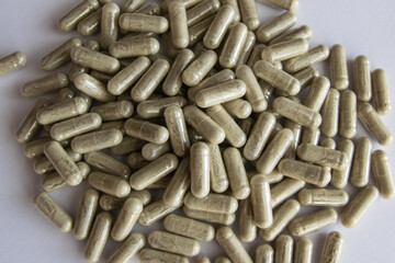 Green tablets or pills on the black stone background.
