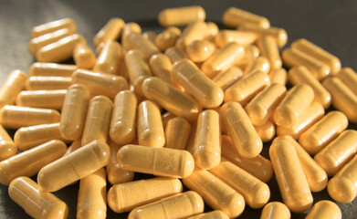 Yellow tablets or pills on the black stone background.