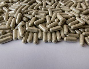 Green tablets or pills on the black stone background.