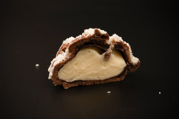 Profiteroles with coconut cream on a black background.