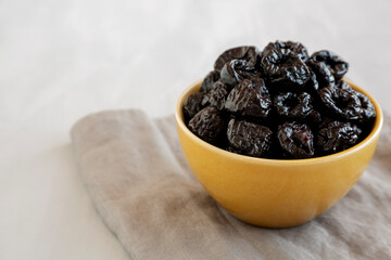 Raw Dried Plum Prunes in a Bowl, side view.