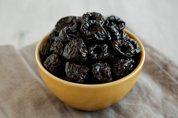 Raw Dried Plum Prunes in a Bowl, side view.