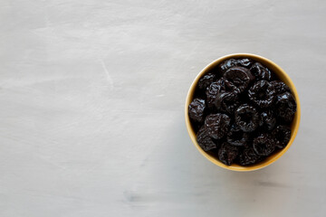 Raw Dried Plum Prunes in a Bowl, top view. Copy space.