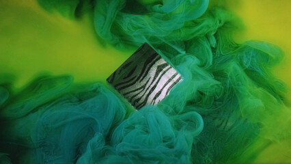 Abstract cube. Sparkle texture. Defocused blue green yellow multicolor haze fume fog paint splash ink on patterned light background.