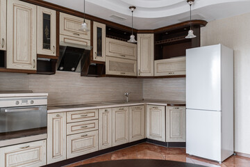 large beige kitchen in retro style. wooden cabinets of built-in kitchen, wooden countertop. large...