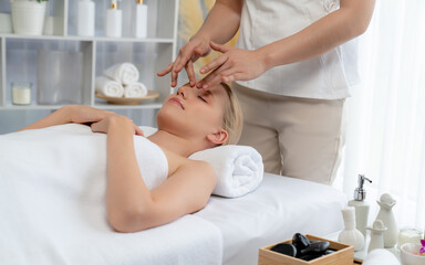 Obraz premium Caucasian woman enjoying relaxing anti-stress head massage and pampering facial beauty skin recreation leisure in dayspa modern light ambient at luxury resort or hotel spa salon. Quiescent
