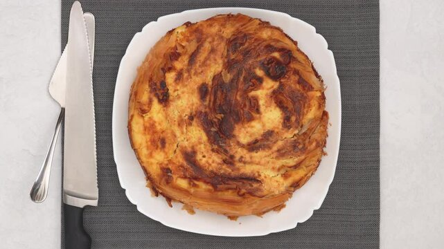 Chef presents a freshly baked phyllo dough pie with a golden crust, showcasing a decadent cream cheese filling. High quality 4k footage