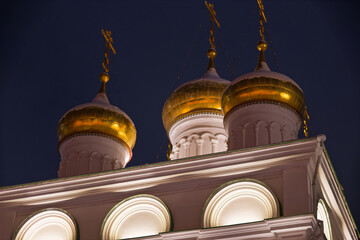 The gold domes of a church tower are lit up at night. Sights of the Nizhny Novgorod Kremlin