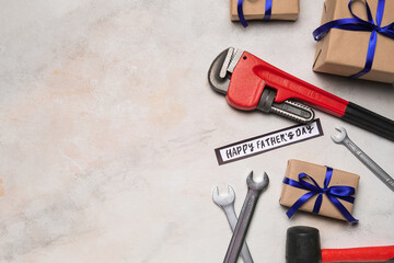 Composition with construction tools and gifts for Father's Day celebration on light background