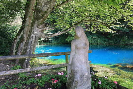 Blick auf die Skulptur sch&ouml;ne Lau und den Blautopf, einer blauen Quelle im Zentrum der Stadt Blaubeuren auf der Schw&auml;bischen Alb in Baden-W&uuml;rttemberg