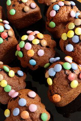 Homemade baked and decorated muffins with colorful chocolate candies from above