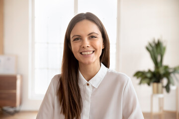 Head shot portrait young woman looking at camera, take part in virtual meeting event, engaged in...