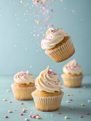 Dreamy vanilla cupcakes with smooth buttercream frosting and pastel sprinkles fall gracefully in a floating bakery scene, full of sweetness and elegance.