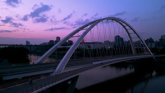 Drone footage of of the Walterdale Bridge in Edmonton, Alberta, Canada at sunset in a purple sky
