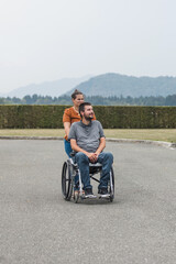 Smiling man, a wheelchair user, and his female assistant enjoying outdoor activity. Disability support concept.