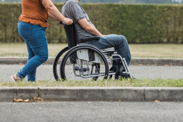 Obraz premium Smiling man, a wheelchair user, and his female assistant enjoying outdoor activity. Disability support concept.
