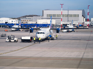 Turboprop aircraft at busy airport tarmac