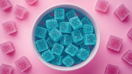 Blue and pink sugared gummies in a bowl on a pastel pink background