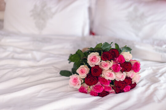 Whispers of Romance: A Beautiful Rose Bouquet Resting on the Bed