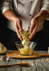 Skilled hands shred crisp cabbage while preparing a traditional coleslaw in a warm, inviting kitchen. The wooden table holds various ingredients, enhancing the culinary atmosphere
