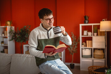 young man read a book and drink coffee in the modern living room