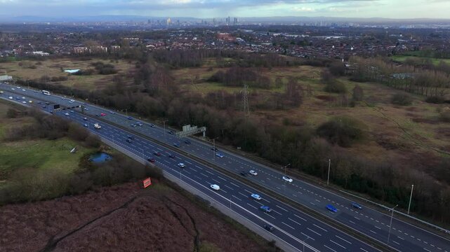 Aerial video of Manchester M60 outer ring road near Swinton area with Manchester skyline on the Horizon. 