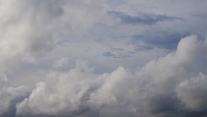 afternoon sky with white clouds and black clouds indicating cloudy weather