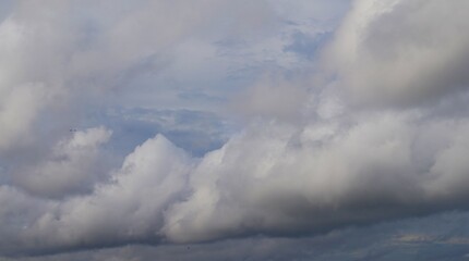 afternoon sky with white clouds and black clouds indicating cloudy weather