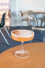 Glass of Cold Orange Mocktail on table,female hand swirling red wine in wine glass,Friends cheering with wineglasses.