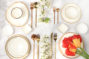 Elegant festive table setting, menu design in a cafe or restaurant for congratulations, festive composition with a bouquet of tulips and cherries, cutlery with flowers on a plate