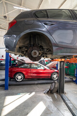 Car service workshop with cars on a column lifts