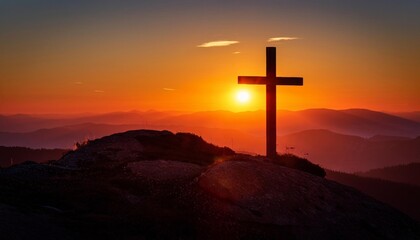 Crucifix Cross stands on a hilltop. Sunset with mountains. Religion symbol. Beautiful landscape with the Christian cross. Faith and hope concept. Orange sky.