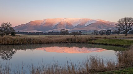Obraz premium Snow Capped Mountain Reflecting in Pond at Dusk Serene Countryside View